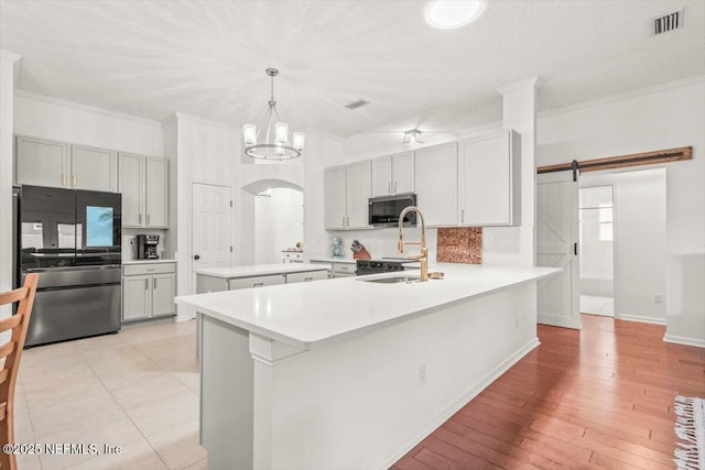 2484 Royal Pointe Dr, Green Cove Springs, FL 32043 - kitchen with stainless steel appliances, a peninsula, crown molding, a chandelier, and light countertops