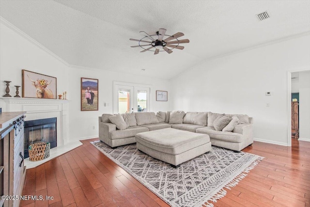 2484 Royal Pointe Dr, Green Cove Springs, FL 32043 - living area with vaulted ceiling, a ceiling fan, hardwood / wood-style flooring, a fireplace with flush hearth, and a textured ceiling