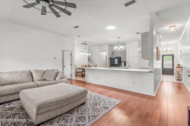 2484 Royal Pointe Dr, Green Cove Springs, FL 32043 - living area with a chandelier, a ceiling fan, a textured ceiling, and light wood-type flooring