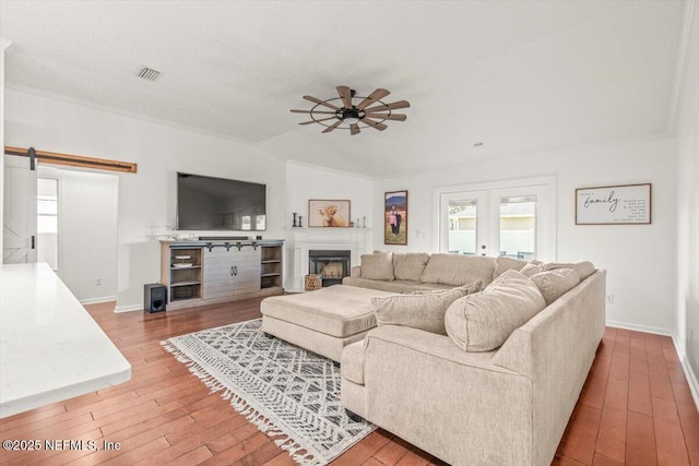 2484 Royal Pointe Dr, Green Cove Springs, FL 32043 - living area with hardwood / wood-style flooring, a ceiling fan, a barn door, vaulted ceiling, and a fireplace