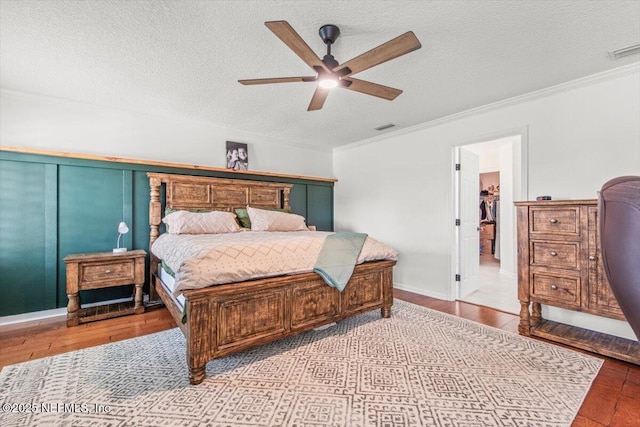 2484 Royal Pointe Dr, Green Cove Springs, FL 32043 - bedroom featuring crown molding, wood finished floors, a textured ceiling, and ceiling fan