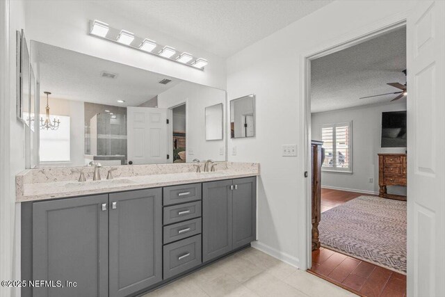 2484 Royal Pointe Dr, Green Cove Springs, FL 32043 - full bath featuring a textured ceiling, double vanity, ceiling fan, a stall shower, and a chandelier