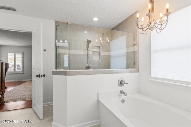 2484 Royal Pointe Dr, Green Cove Springs, FL 32043 - bathroom featuring a textured ceiling, walk in shower, a bath, a chandelier, and tile patterned floors