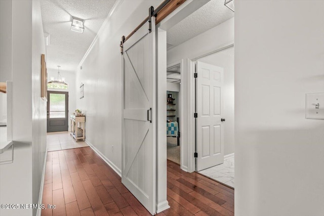 2484 Royal Pointe Dr, Green Cove Springs, FL 32043 - corridor featuring a barn door, wood finished floors, a textured ceiling, crown molding, and a chandelier