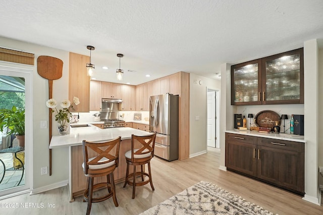 603 Miramar Ct, Ponte Vedra Beach, FL 32082 - kitchen with stainless steel fridge with ice dispenser, light wood-style flooring, light countertops, a peninsula, and a textured ceiling