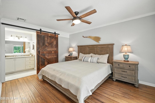 603 Miramar Ct, Ponte Vedra Beach, FL 32082 - bedroom featuring a barn door, crown molding, hardwood / wood-style flooring, ensuite bath, and ceiling fan