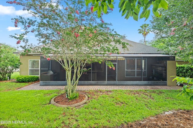 2269 Cascadia Ct, Saint Augustine, FL 32092 - back of property featuring a sunroom, a yard, stucco siding, and a shingled roof