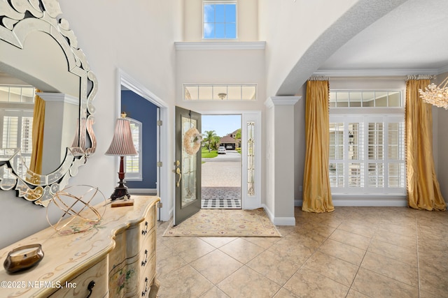2269 Cascadia Ct, Saint Augustine, FL 32092 - entrance foyer featuring plenty of natural light, light tile patterned flooring, ornate columns, a towering ceiling, and arched walkways