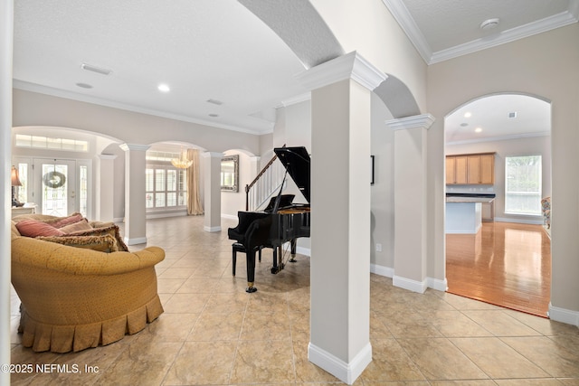 2269 Cascadia Ct, Saint Augustine, FL 32092 - living area with decorative columns, arched walkways, crown molding, light tile patterned floors, and stairs
