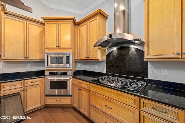 2269 Cascadia Ct, Saint Augustine, FL 32092 - kitchen featuring appliances with stainless steel finishes, wall chimney exhaust hood, dark wood-type flooring, crown molding, and dark stone countertops