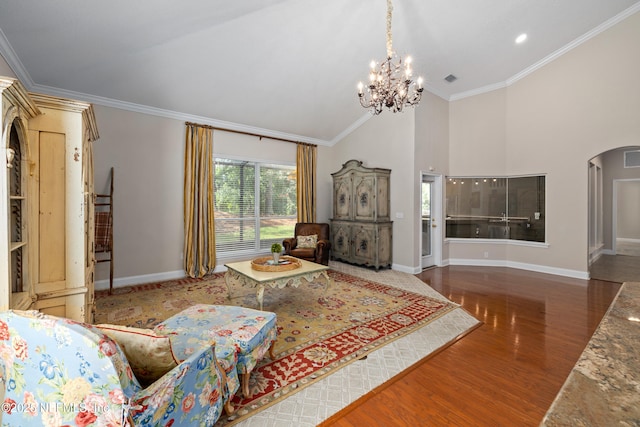 2269 Cascadia Ct, Saint Augustine, FL 32092 - living room featuring arched walkways, a chandelier, ornamental molding, wood finished floors, and a high ceiling