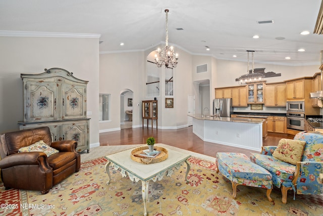 2269 Cascadia Ct, Saint Augustine, FL 32092 - living room with a chandelier, arched walkways, crown molding, high vaulted ceiling, and recessed lighting