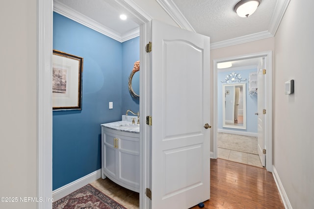 2269 Cascadia Ct, Saint Augustine, FL 32092 - bathroom featuring vanity, a textured ceiling, wood finished floors, and ornamental molding