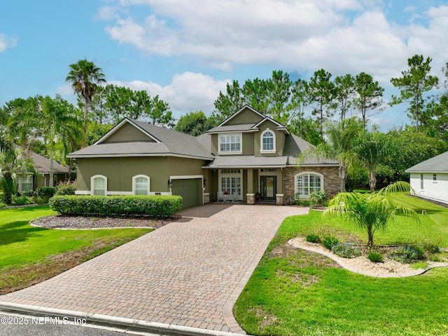 2269 Cascadia Ct, Saint Augustine, FL 32092 - traditional-style home featuring stone siding, a garage, stucco siding, decorative driveway, and a front yard