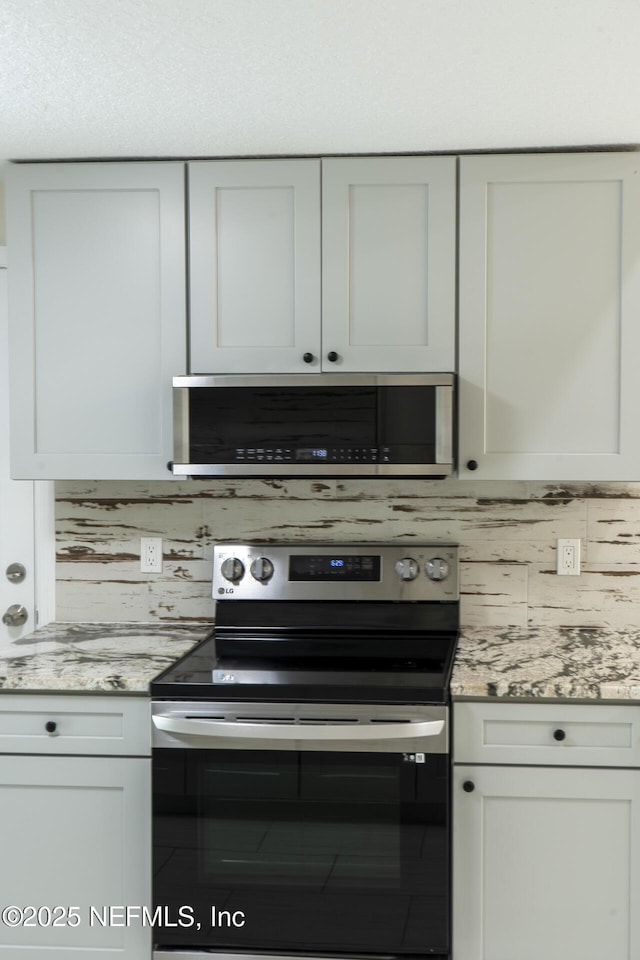8305 Coralberry Ln, Jacksonville, FL 32244 - kitchen featuring stainless steel appliances, decorative backsplash, and light stone countertops