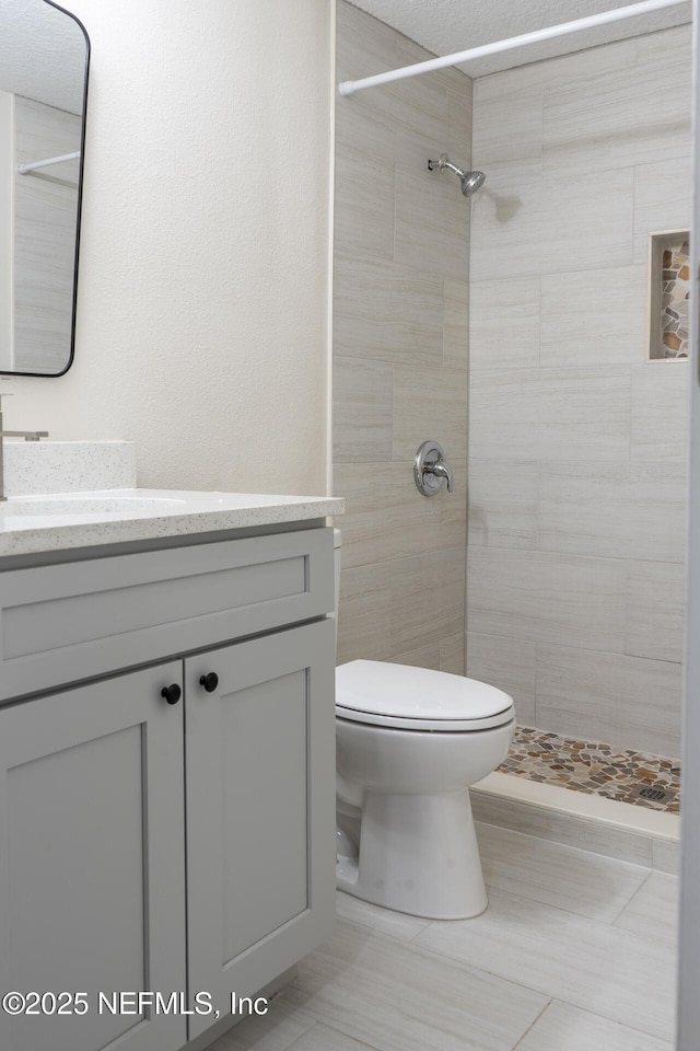 8305 Coralberry Ln, Jacksonville, FL 32244 - full bathroom featuring vanity, a tile shower, and tile patterned flooring