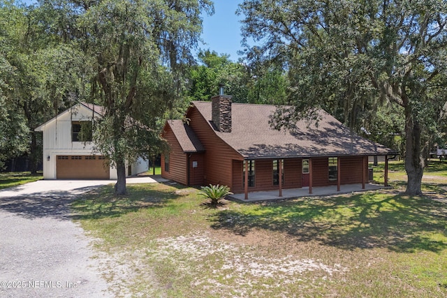 2871 Anchor Rd, Middleburg, FL 32068 - view of front of house with driveway, covered porch, a front yard, a garage, and a chimney
