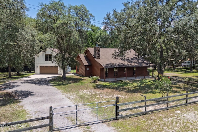 2871 Anchor Rd, Middleburg, FL 32068 - view of front facade with dirt driveway, a porch, a garage, a gate, and a chimney