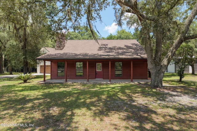 2871 Anchor Rd, Middleburg, FL 32068 - chalet / cabin featuring a front yard, a shingled roof, log veneer siding, and a chimney