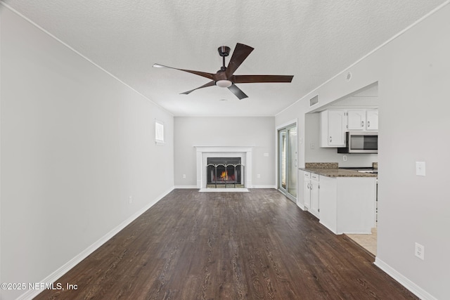 2300 Twelve Oaks Dr Unit K-14, Orange Park, FL 32065 - unfurnished living room with a ceiling fan, dark wood-style flooring, a fireplace with flush hearth, and a textured ceiling