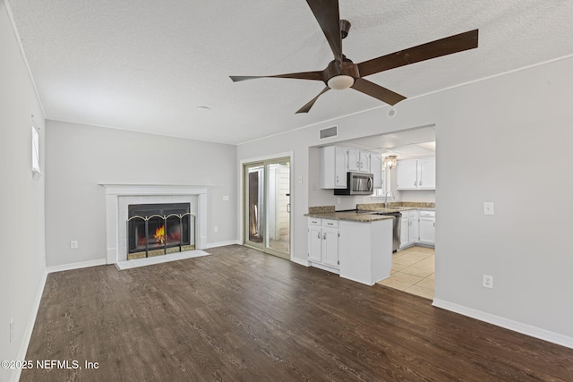 2300 Twelve Oaks Dr Unit K-14, Orange Park, FL 32065 - unfurnished living room with a textured ceiling, wood finished floors, a fireplace with flush hearth, and ceiling fan