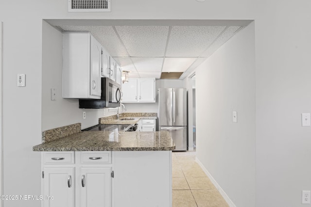 2300 Twelve Oaks Dr Unit K-14, Orange Park, FL 32065 - kitchen with appliances with stainless steel finishes, a paneled ceiling, white cabinets, a peninsula, and light tile patterned floors