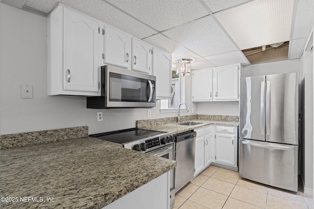 2300 Twelve Oaks Dr Unit K-14, Orange Park, FL 32065 - kitchen with appliances with stainless steel finishes, white cabinets, a paneled ceiling, light tile patterned floors, and stone countertops
