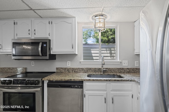2300 Twelve Oaks Dr Unit K-14, Orange Park, FL 32065 - kitchen featuring stainless steel appliances, white cabinets, a paneled ceiling, and light stone countertops