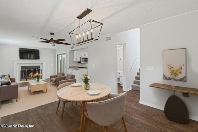 2300 Twelve Oaks Dr Unit K-14, Orange Park, FL 32065 - dining room with stairway, dark wood-style flooring, a textured ceiling, ceiling fan, and a warm lit fireplace
