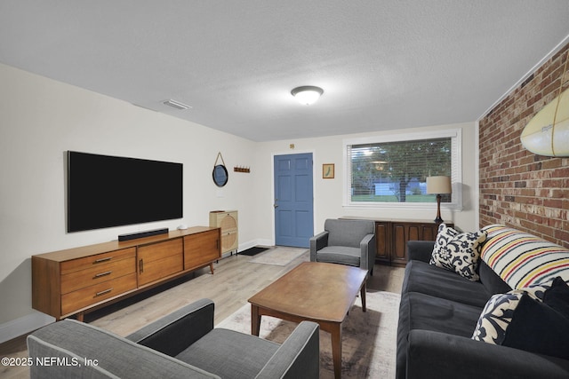 239 Glynlea Rd, Jacksonville, FL 32216 - living area featuring light wood-style flooring, brick wall, and a textured ceiling