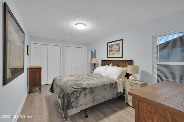 239 Glynlea Rd, Jacksonville, FL 32216 - bedroom featuring multiple closets, light wood-style flooring, and a textured ceiling