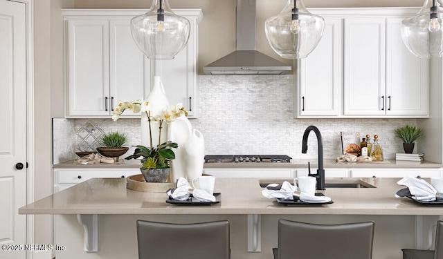 523 White Rabbit Run, Saint Augustine, FL 32092 - kitchen featuring wall chimney range hood, stainless steel gas cooktop, white cabinetry, and light countertops