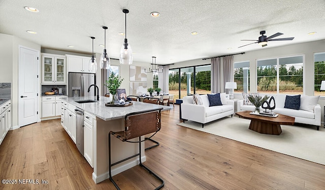 523 White Rabbit Run, Saint Augustine, FL 32092 - kitchen with appliances with stainless steel finishes, open floor plan, a textured ceiling, ceiling fan, and a breakfast bar