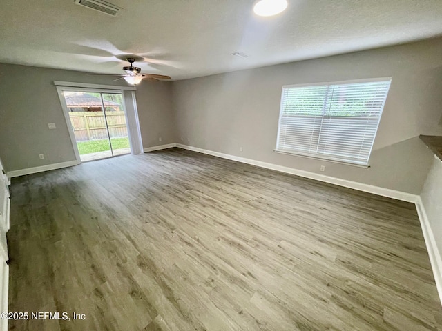 86069 Pineview Dr, Yulee, FL 32097 - empty room with wood finished floors, ceiling fan, and a textured ceiling