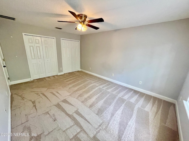 86069 Pineview Dr, Yulee, FL 32097 - unfurnished bedroom with carpet, two closets, and a ceiling fan