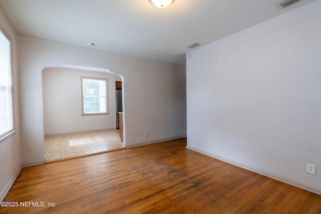 3312 Dellwood Ave, Jacksonville, FL 32205 - spare room featuring wood-type flooring, arched walkways, and a textured ceiling