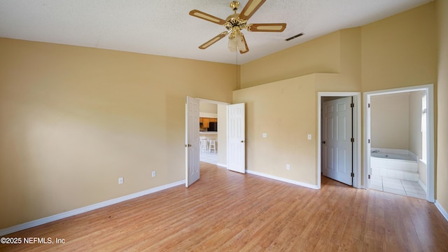 2109 Hovington Cir W, Jacksonville, FL 32246 - unfurnished bedroom with light wood finished floors, high vaulted ceiling, ensuite bathroom, a textured ceiling, and a ceiling fan