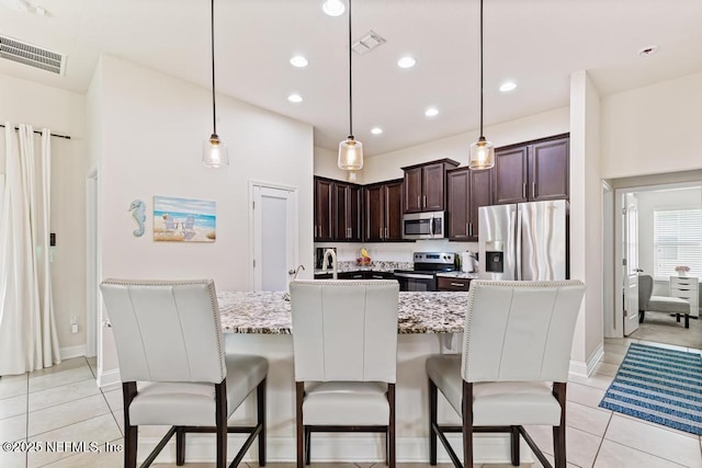 75078 Glenspring Way, Yulee, FL 32097 - kitchen featuring appliances with stainless steel finishes, dark brown cabinetry, light tile patterned flooring, a breakfast bar area, and recessed lighting