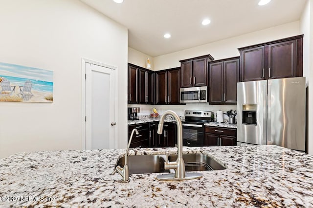 75078 Glenspring Way, Yulee, FL 32097 - kitchen featuring stainless steel appliances, light stone counters, recessed lighting, and dark brown cabinets