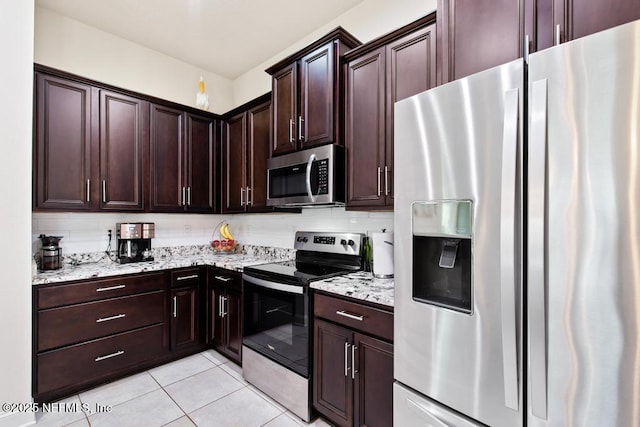 75078 Glenspring Way, Yulee, FL 32097 - kitchen with appliances with stainless steel finishes, light tile patterned flooring, light stone counters, and dark brown cabinetry