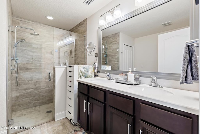 75078 Glenspring Way, Yulee, FL 32097 - bathroom featuring double vanity, a shower stall, and a textured ceiling