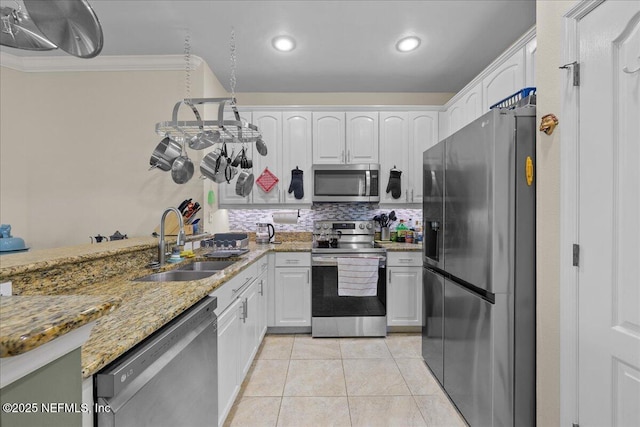 25 Riverview Bnd N Unit 122, Palm Coast, FL 32137 - kitchen with stainless steel appliances, white cabinets, light stone counters, light tile patterned floors, and ornamental molding