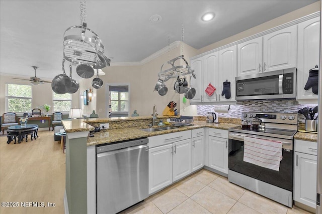 25 Riverview Bnd N Unit 122, Palm Coast, FL 32137 - kitchen with appliances with stainless steel finishes, a peninsula, healthy amount of natural light, white cabinets, and ornamental molding