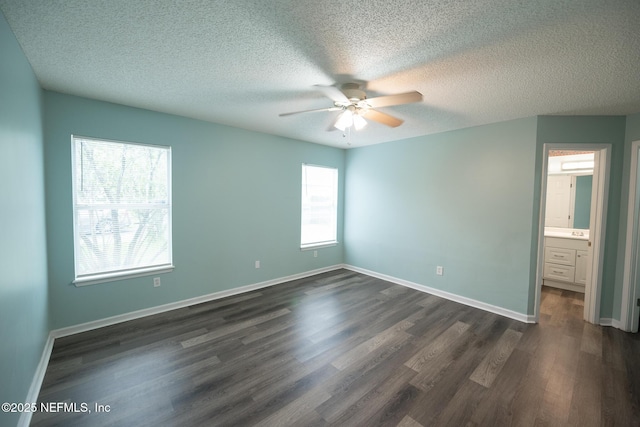 3013 Wavering Ln, Middleburg, FL 32068 - unfurnished bedroom with dark wood-style flooring, a textured ceiling, a ceiling fan, and connected bathroom