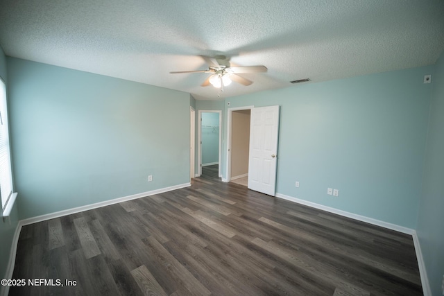 3013 Wavering Ln, Middleburg, FL 32068 - unfurnished bedroom with dark wood-type flooring, a textured ceiling, a walk in closet, and a ceiling fan