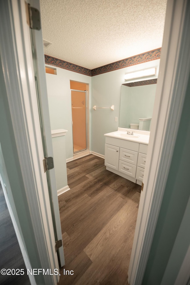 3013 Wavering Ln, Middleburg, FL 32068 - bathroom featuring vanity, a shower stall, a textured ceiling, and wood finished floors