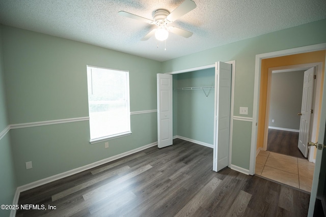 3013 Wavering Ln, Middleburg, FL 32068 - unfurnished bedroom featuring dark wood-style flooring, a closet, a textured ceiling, and a ceiling fan