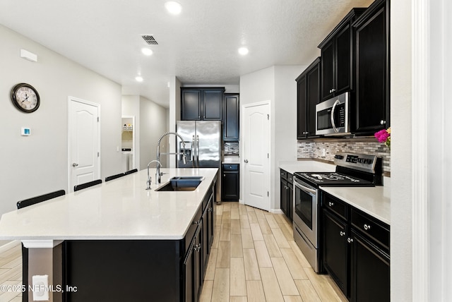 9217 Gilmore Grove Way, Jacksonville, FL 32211 - kitchen with stainless steel appliances, dark cabinetry, tasteful backsplash, and recessed lighting