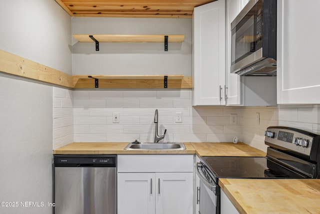 243 Ravenswood Dr, Saint Augustine, FL 32084 - kitchen featuring wood counters, appliances with stainless steel finishes, white cabinets, and tasteful backsplash
