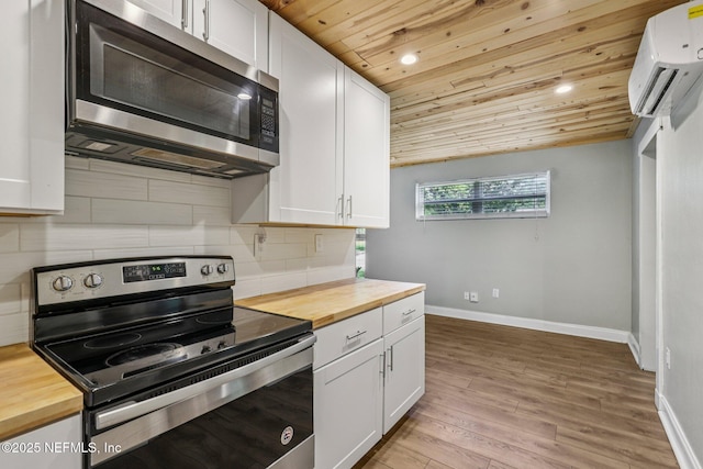 243 Ravenswood Dr, Saint Augustine, FL 32084 - kitchen with stainless steel appliances, wooden counters, wood ceiling, a wall mounted AC, and white cabinetry